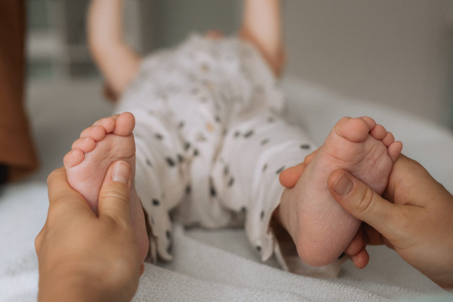 Saphira hält Akupressurpunkte eines Babys während einer Kinesiologiesitzung